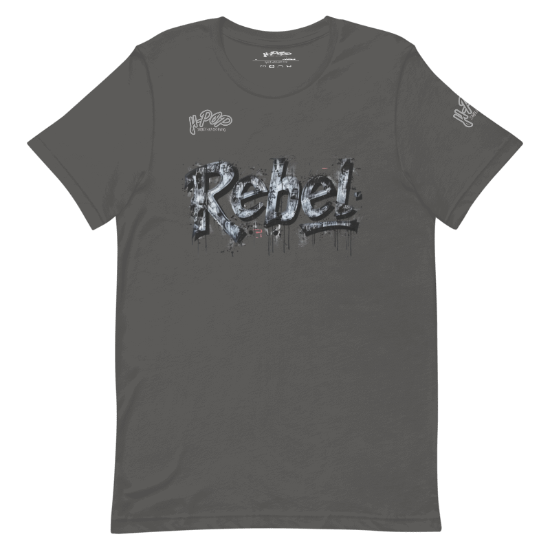 T-shirt grigio antracite con una stampa grafica centrale che recita "Rebel" in stile graffito, con un effetto ruvido, consumato e gocciolante, in tonalità di grigio e bianco. Il design ha un'estetica ribelle e urbana. L'immagine è presentata su uno sfondo trasparente.
