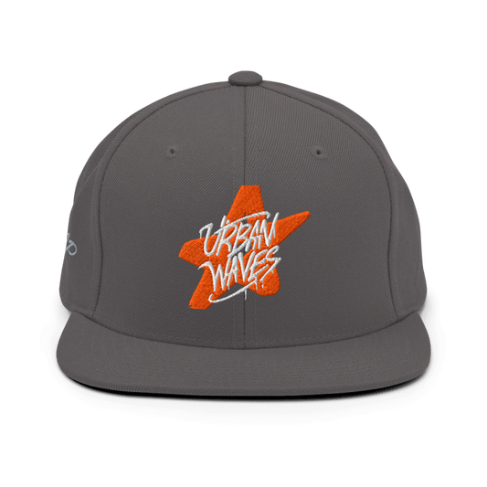 Cappellino snapback grigio con ricamo di una stella arancione stilizzata e la scritta "URBAN WAVES" in bianco. Un logo aggiuntivo è ricamato in arancione sul lato sinistro. Ideale per un look casual e streetwear. Parole chiave: cappellino, snapback, grigio, arancione, stella, urban, streetwear, moda, abbigliamento, accessori, stile, tendenza, Italia.