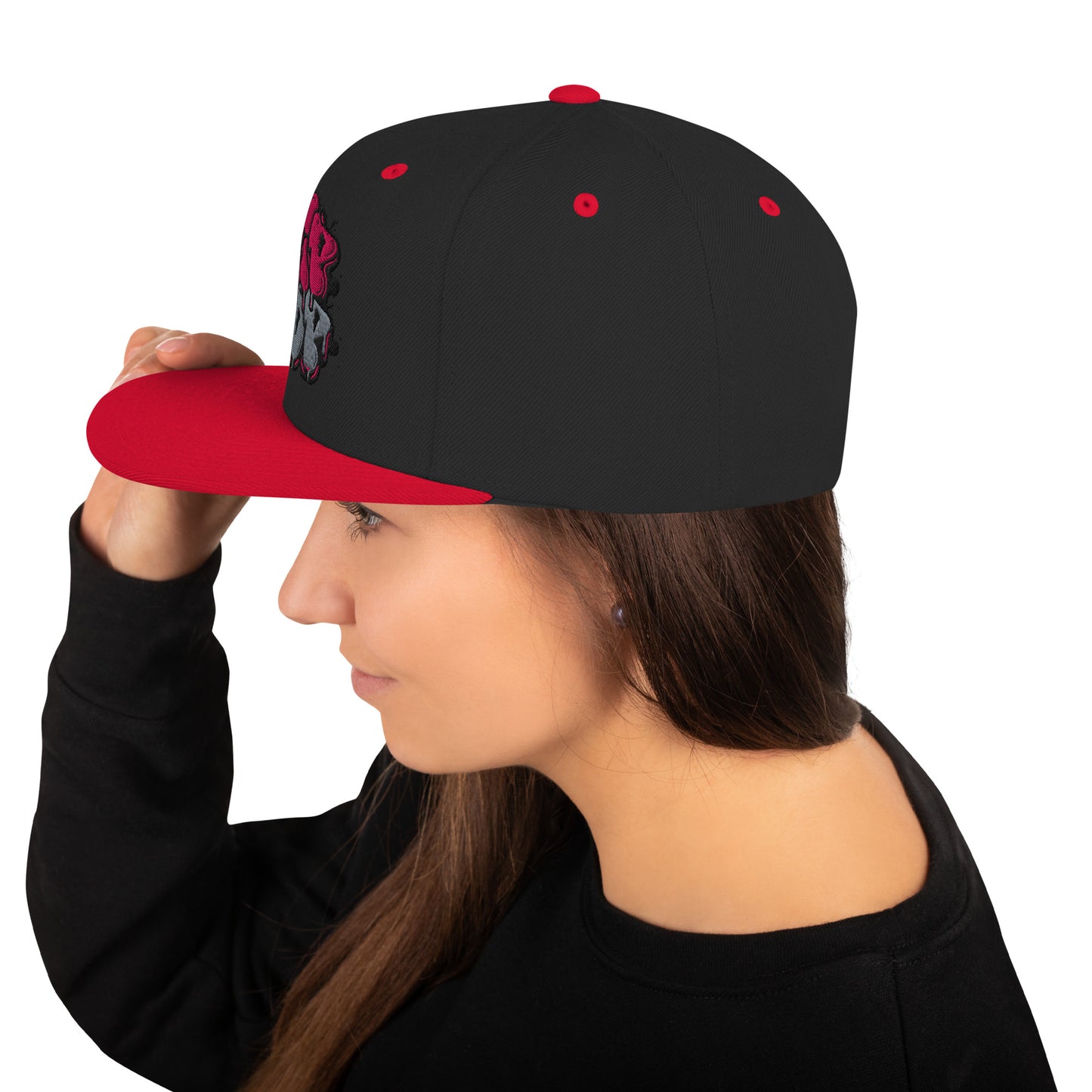 Profilo di una donna che indossa un cappellino snapback nero con visiera piatta rossa e una grafica frontale che richiama il lettering 'Hip Hop' con dettagli rosa e grigi. Perfetto per un look streetwear distintivo. Parole chiave: cappellino, cappellino snapback, cappellino Hip Hop, streetwear, moda urbana, accessori moda, cappellino nero e rosso, stile graffiti, abbigliamento H-Pop, tendenze moda Italia.