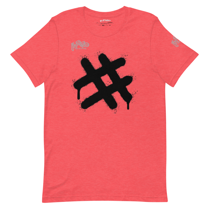 T-shirt color corallo/rosa salmone con una grande stampa centrale nera in stile graffito, raffigurante un simbolo di hashtag (#) con un effetto gocciolante. Il design ha un'estetica urbana e audace. L'immagine è presentata su uno sfondo trasparente.