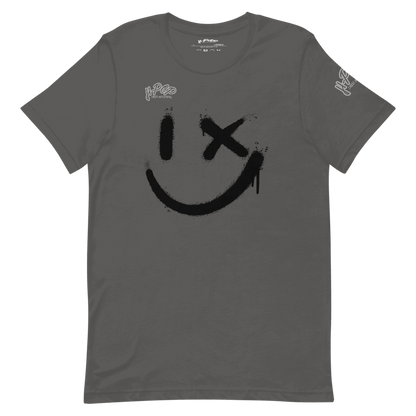 Una maglietta grigio scuro con una grande stampa nera di uno smiley stilizzato: un occhio è un tratto verticale e l'altro una "X", con un effetto vernice spray e gocciolante. La maglietta ha anche il logo "H-Pop" in alto a sinistra e sulla manica.