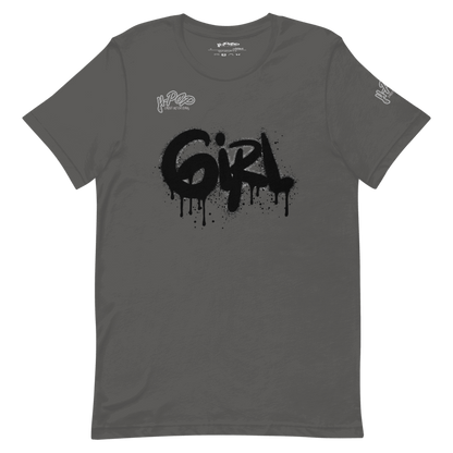 T-shirt grigio antracite con una stampa grafica centrale che recita "GIRL" in stile graffito nero, con un effetto spray e gocciolante. Il design ha un'estetica urbana e audace. L'immagine è presentata su uno sfondo trasparente.