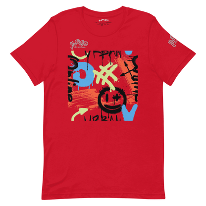 T-shirt rossa con una vivace stampa grafica in stile graffiti al centro. Il design include tratti di pennello, simboli e testo stilizzato in colori come blu, arancione, verde lime e nero, con una faccina sorridente stilizzata. L'immagine è presentata su uno sfondo trasparente.