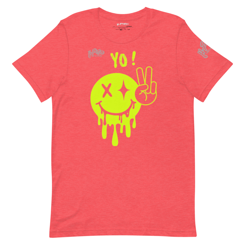 Una maglietta rosso corallo con una grande stampa grafica centrale verde lime di uno smiley stilizzato e gocciolante. Lo smiley ha un occhio a "X" e l'altro una "X" con due stelle, e accanto un gesto della mano che mostra il segno della pace. Sopra lo smiley c'è la scritta "YO!". Il logo "H-Pop" è presente in alto a sinistra e sulla manica sinistra.