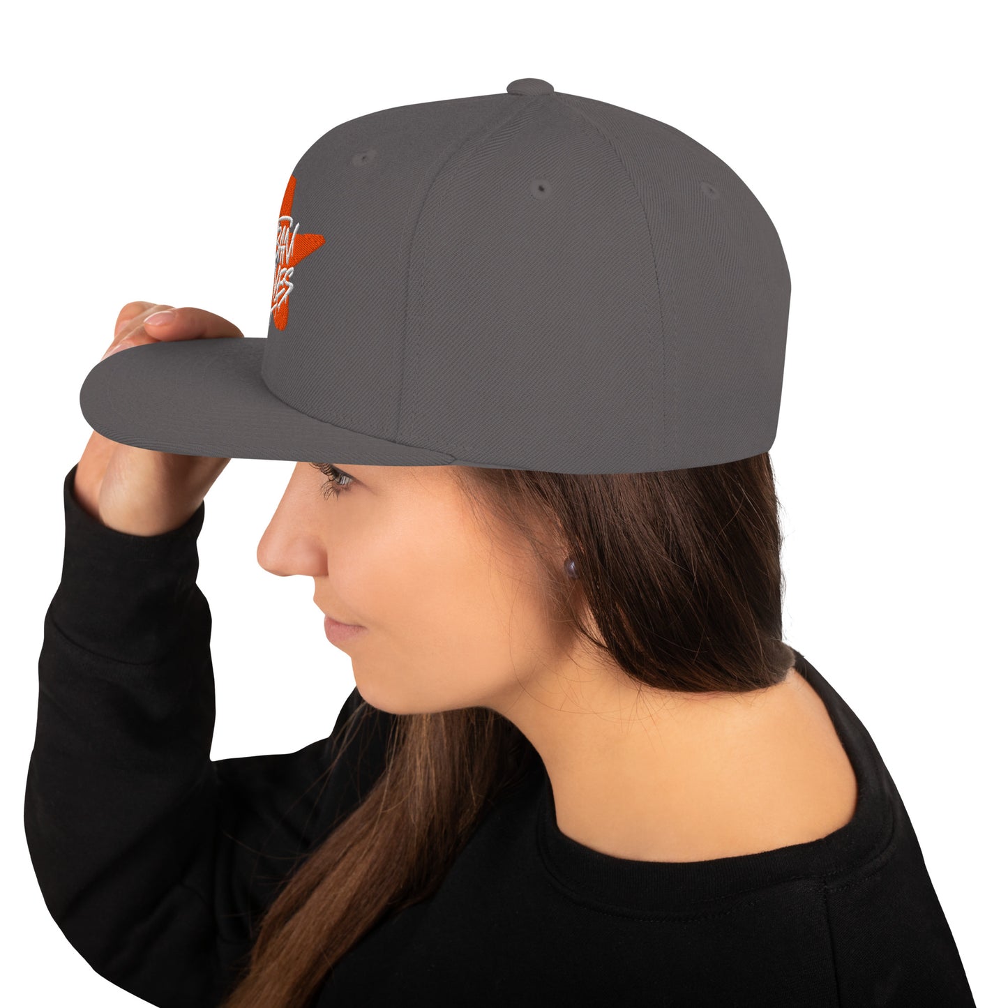 Profilo di donna che indossa un cappello snapback grigio con logo laterale arancione a stella 'Urban Waves'. Ideale per un look streetwear e casual. Cappelli personalizzabili e alla moda per uomo e donna.